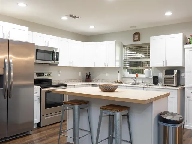 a kitchen with stainless steel appliances a sink stove and refrigerator
