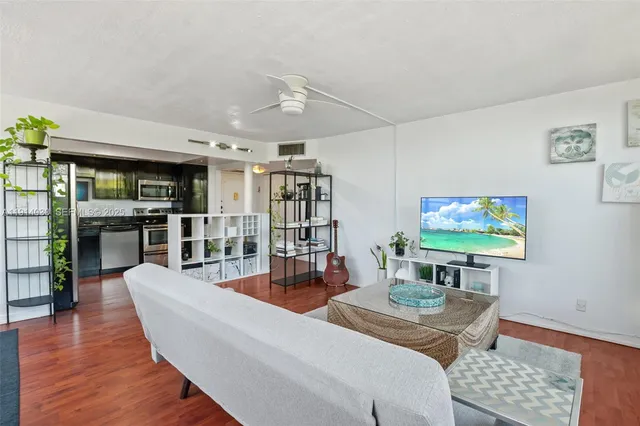 a living room with furniture a rug and a flat screen tv