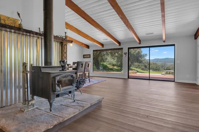 a view of a room with wooden floor and a floor to ceiling window