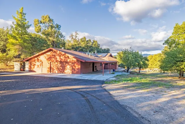 a view of a house with a big yard and large trees