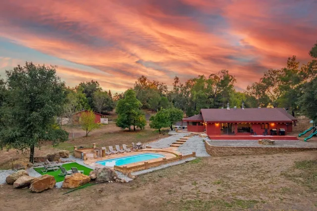 an aerial view of a house with a mountain