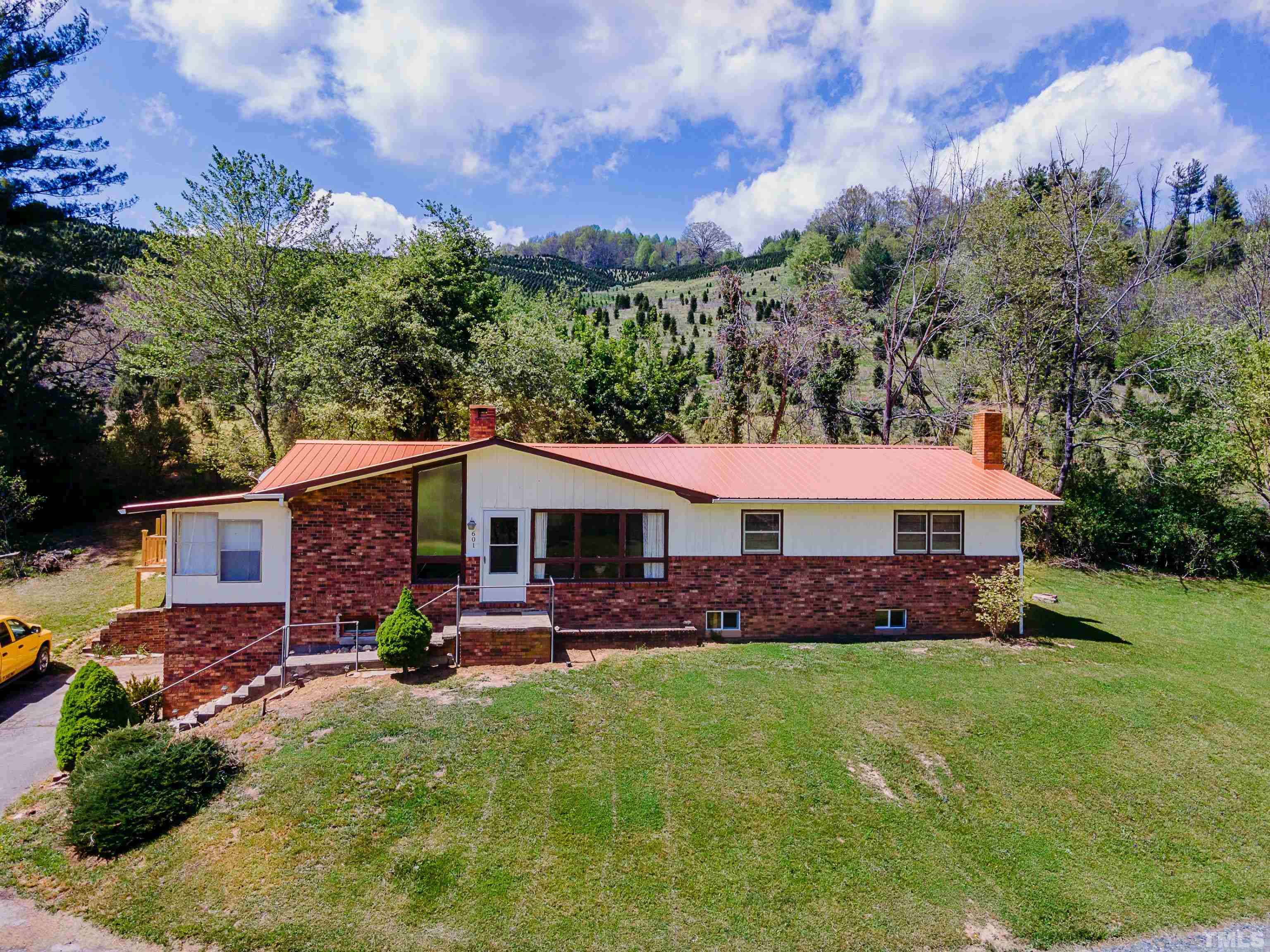 601 Fees Branch Road Lansing, NC 28643 - Photo 1 of 72 a front view of a house with a garden and trees