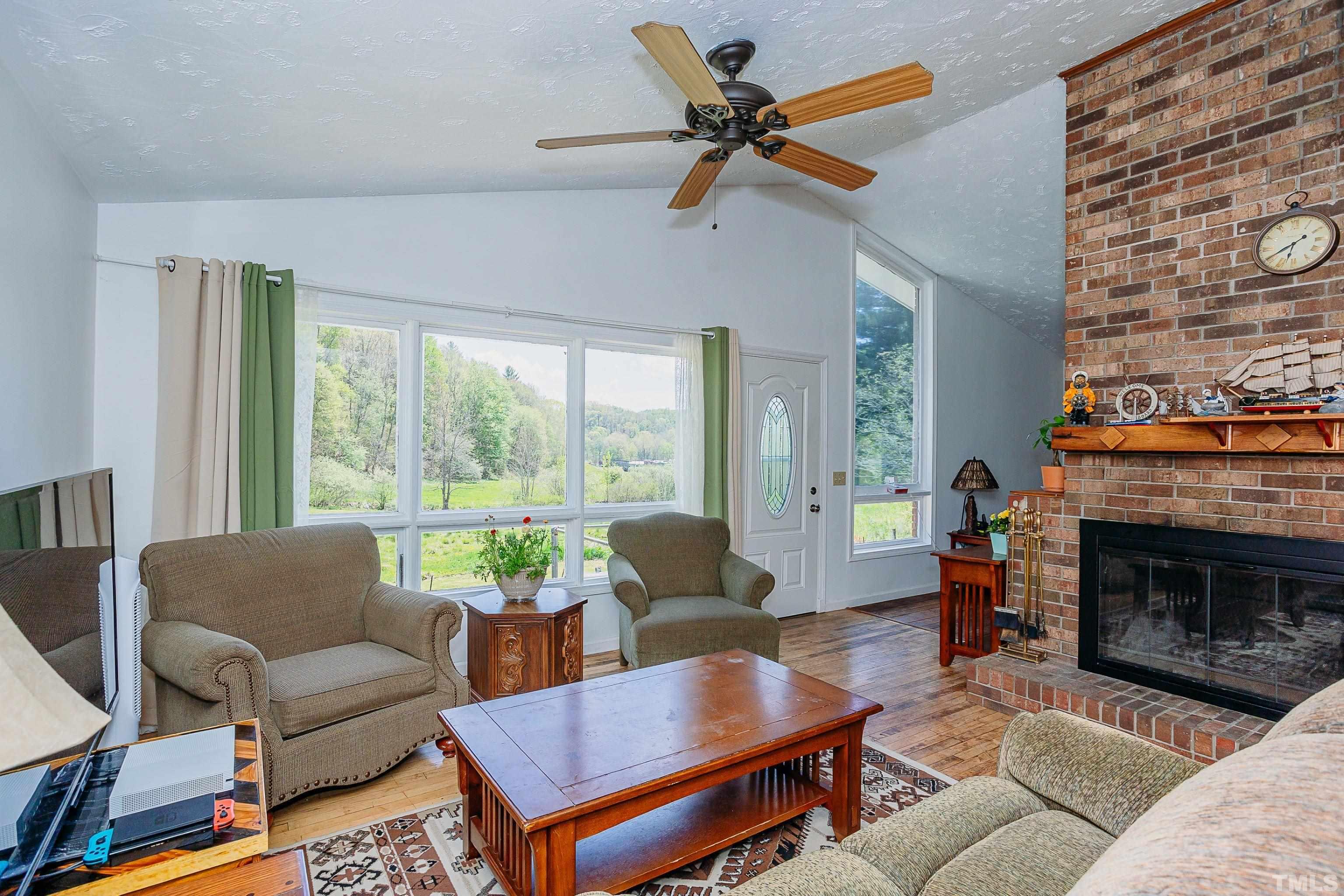 601 Fees Branch Road Lansing, NC 28643 - Photo 20 of 72 a living room with furniture a fireplace a rug and a large window
