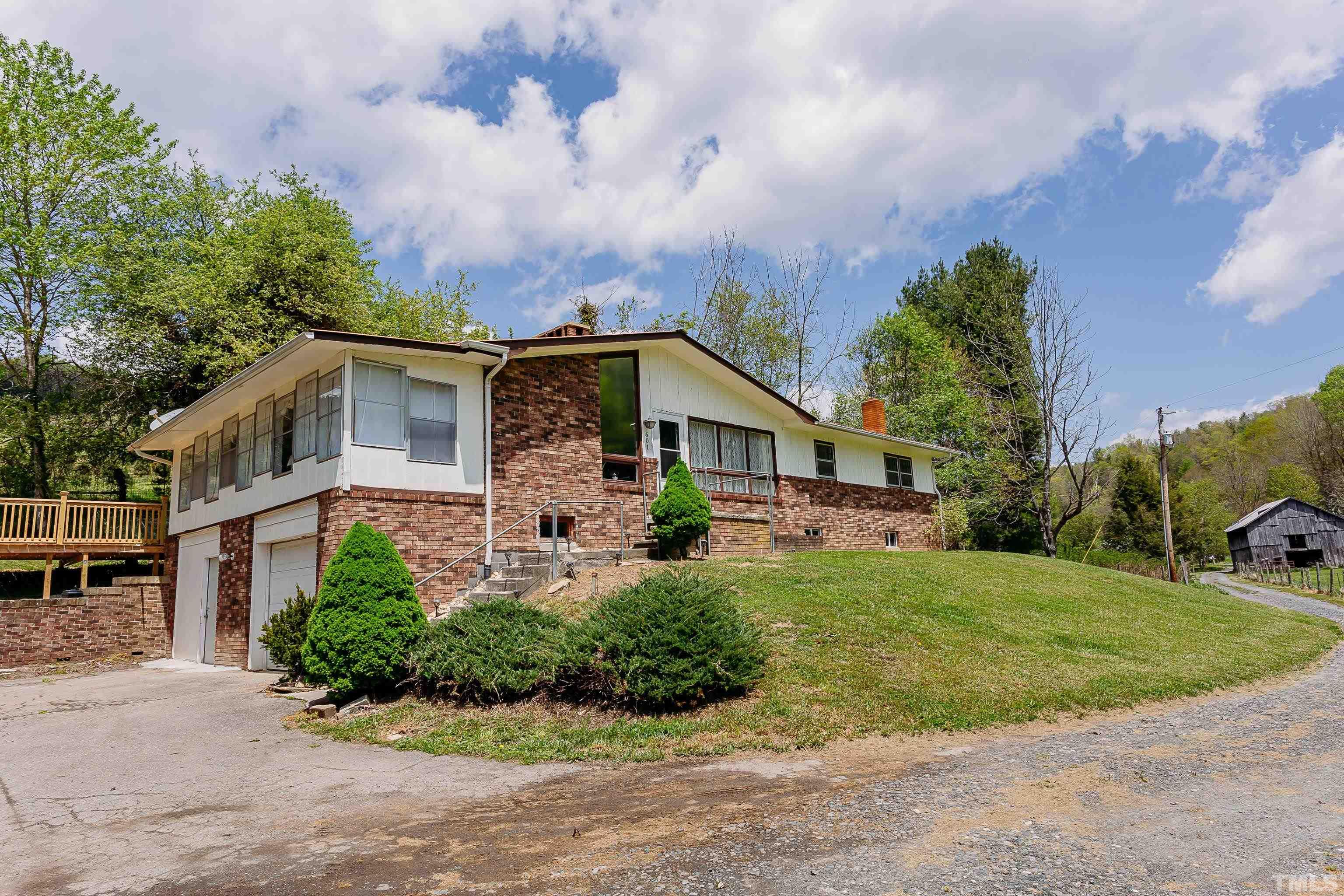 601 Fees Branch Road Lansing, NC 28643 - Photo 2 of 72 a front view of a house with a garden