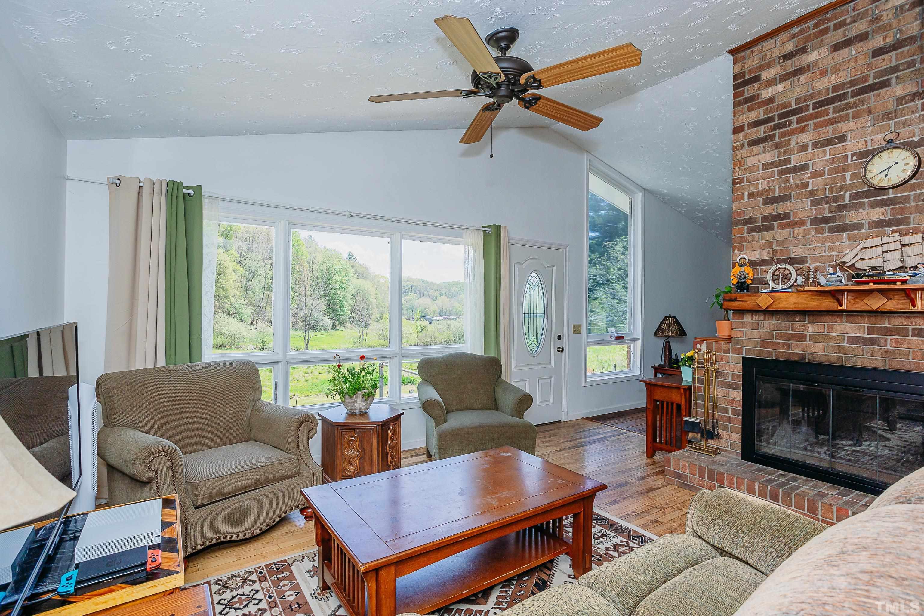 601 Fees Branch Road Lansing, NC 28643 - Photo 44 of 72 a living room with furniture a fireplace a rug and a large window