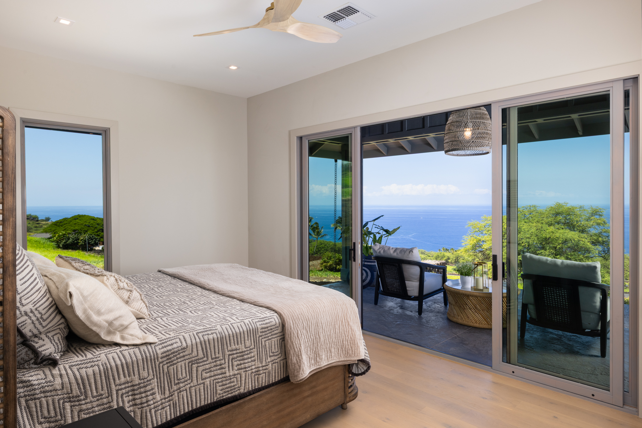 81-6513 Laupai Way Captain Cook, HI 96704 - Photo 21 of 30 a bedroom with a bed a table and a large window