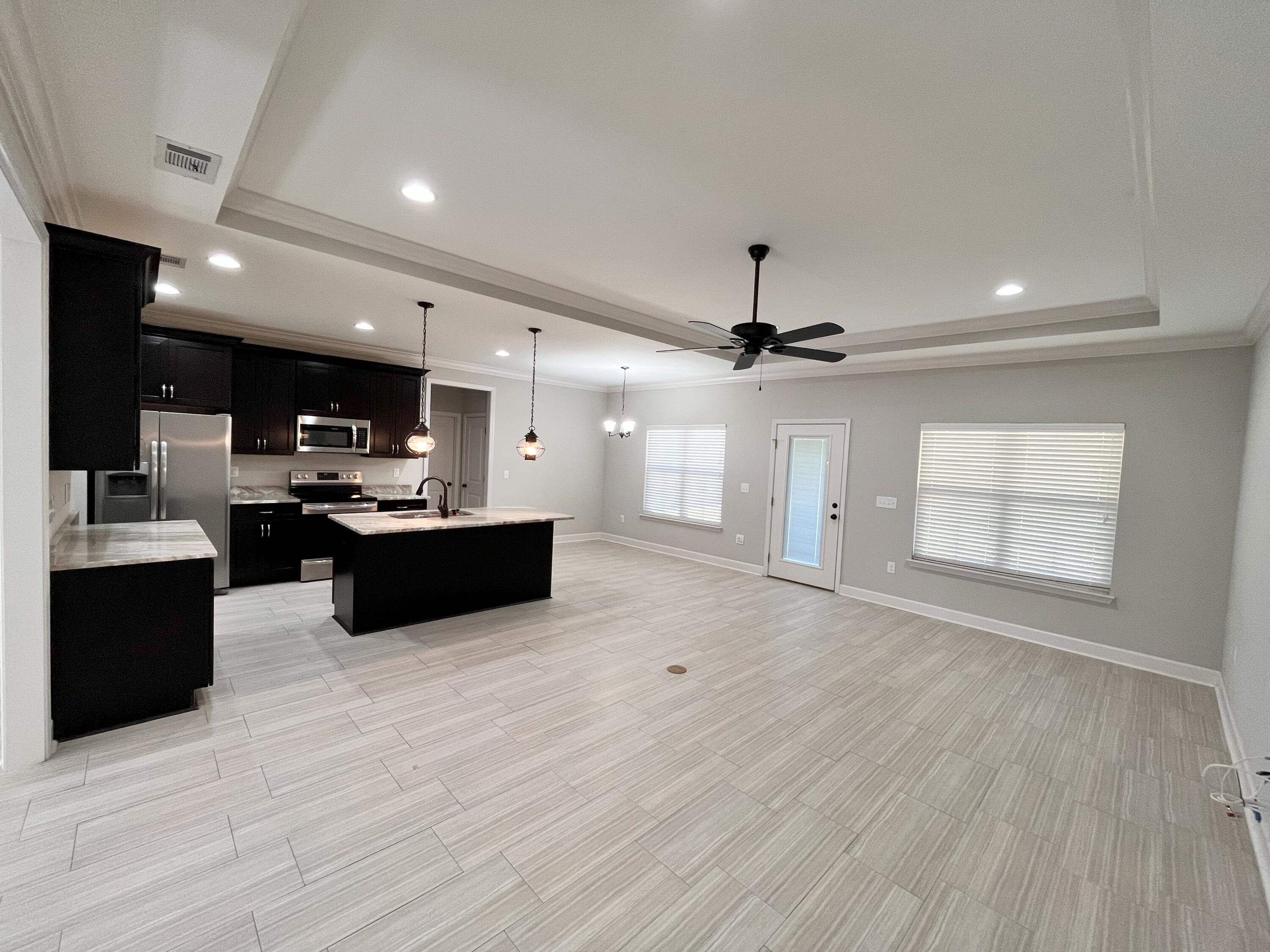 5182 Rabbit Run Crestview, FL 32539 - Photo 20 of 35 a large kitchen with kitchen island a stove a sink dishwasher and a oven with wooden floor