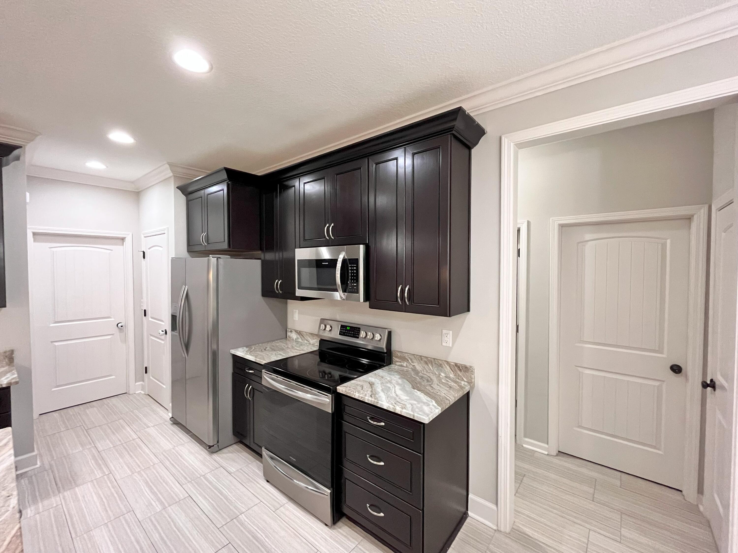 5182 Rabbit Run Crestview, FL 32539 - Photo 23 of 35 a kitchen with a refrigerator and a stove top oven