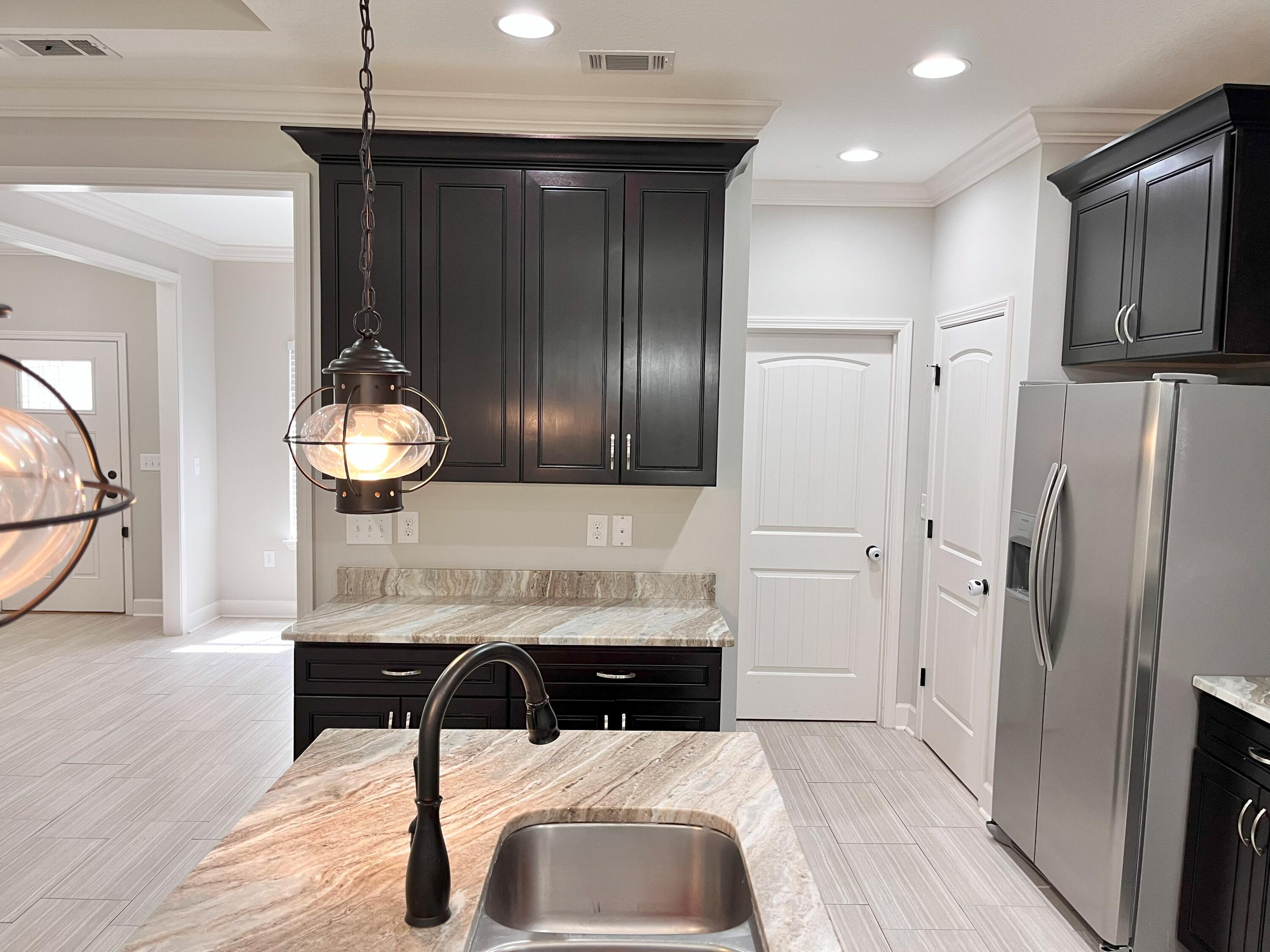 5182 Rabbit Run Crestview, FL 32539 - Photo 25 of 35 a kitchen with stainless steel appliances a refrigerator and wooden floor