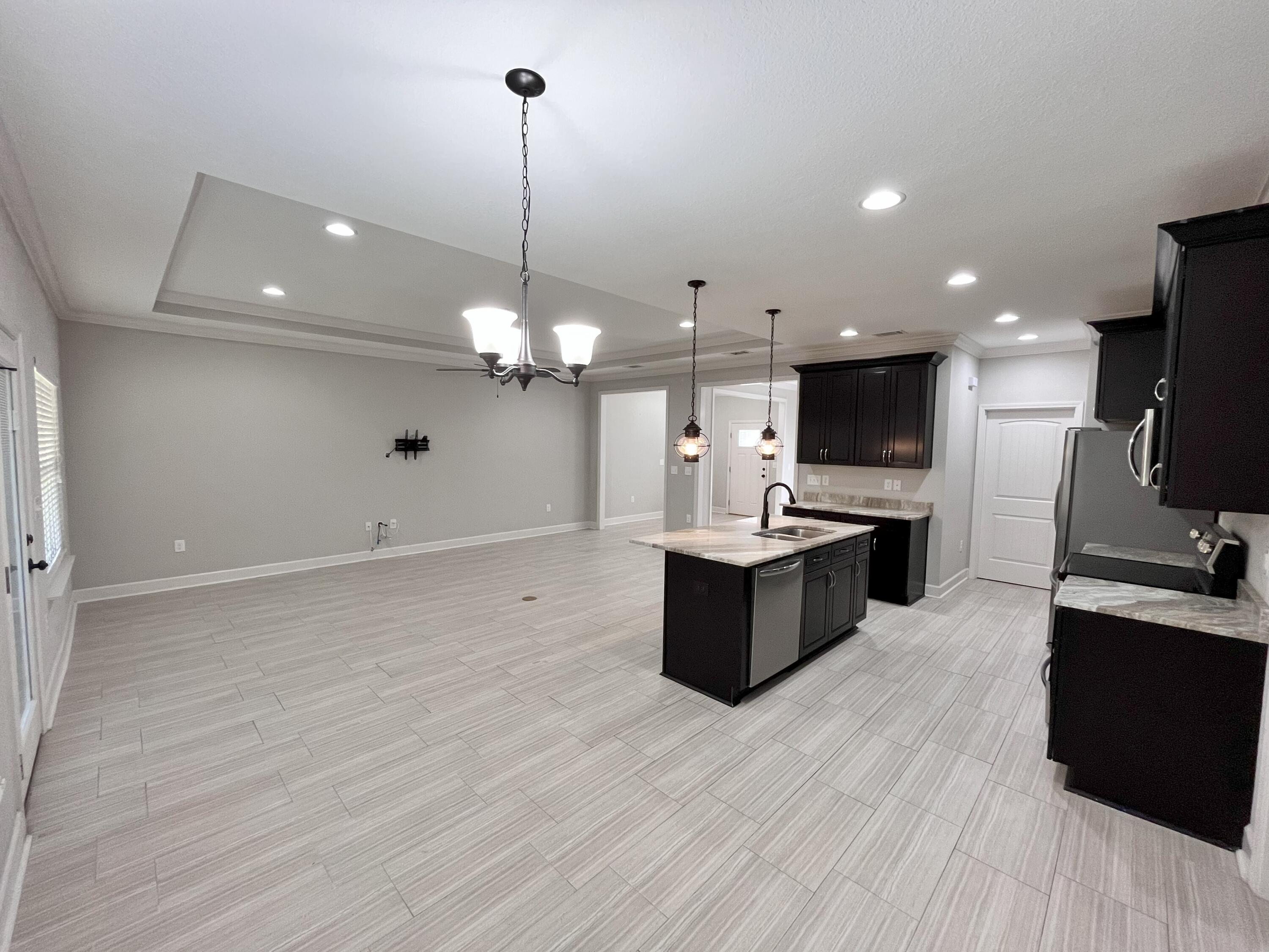 5182 Rabbit Run Crestview, FL 32539 - Photo 28 of 35 a large kitchen with stainless steel appliances a large counter top a sink a stove and a wooden floor