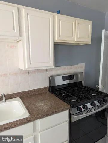 a kitchen with granite countertop white cabinets and white appliances