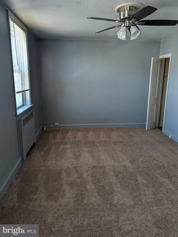 an empty room with windows and ceiling fan