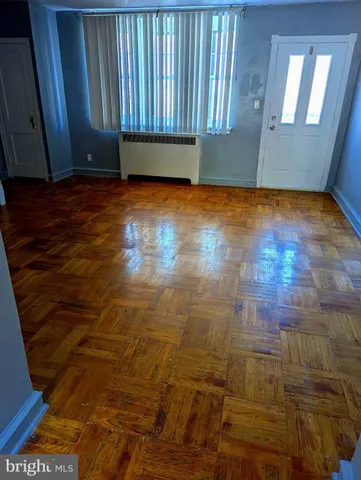 a view of a room with wooden floor and a window