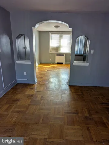 a view of a hallway with wooden floor and a living room