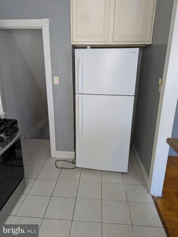 a white refrigerator freezer and a stove sitting inside of a kitchen