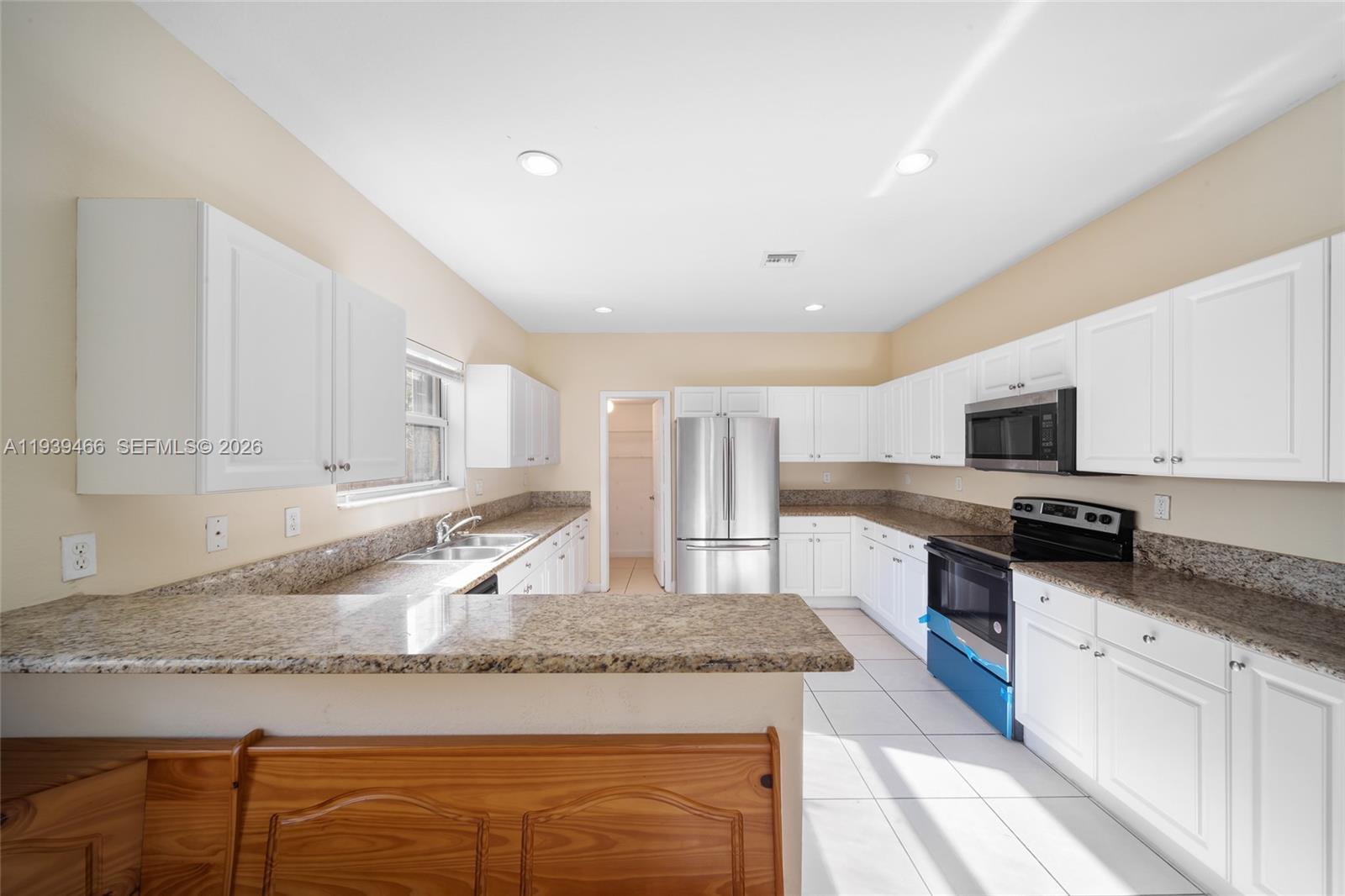3641 Northeast 4th Street Homestead, FL 33033 - Photo 6 of 29 a kitchen with granite countertop a sink a stove top oven a counter space and cabinets