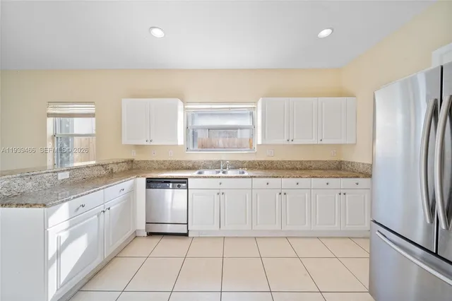 a kitchen with stainless steel appliances granite countertop a stove a sink and a refrigerator