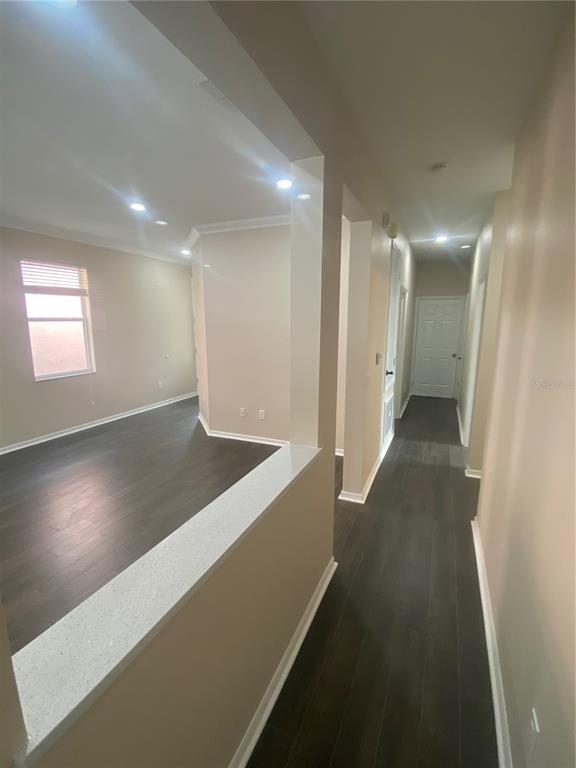2409 Spring Hollow Loop Wesley Chapel, FL 33544 - Photo 7 of 47 an empty room with wooden floor and windows