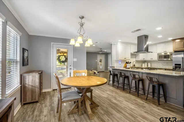 a kitchen with kitchen island a dining table and chairs