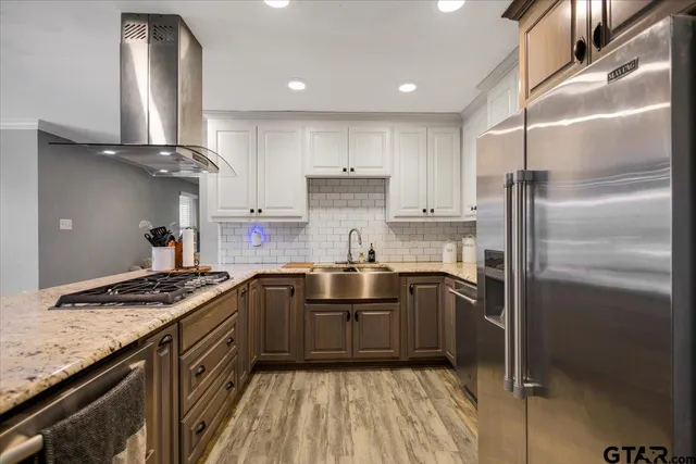 a kitchen with stainless steel appliances granite countertop a sink stove and refrigerator