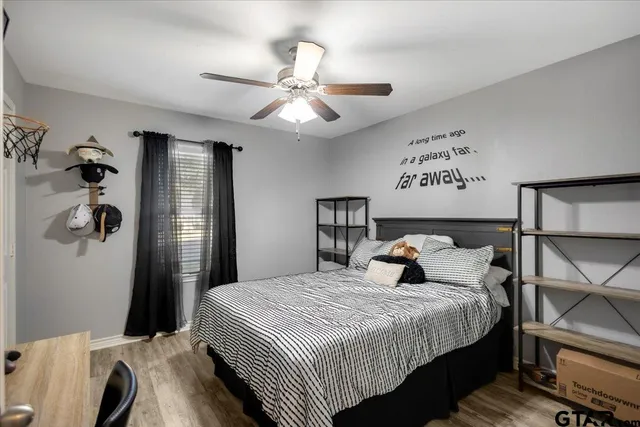 a bedroom with a large bed and a chandelier