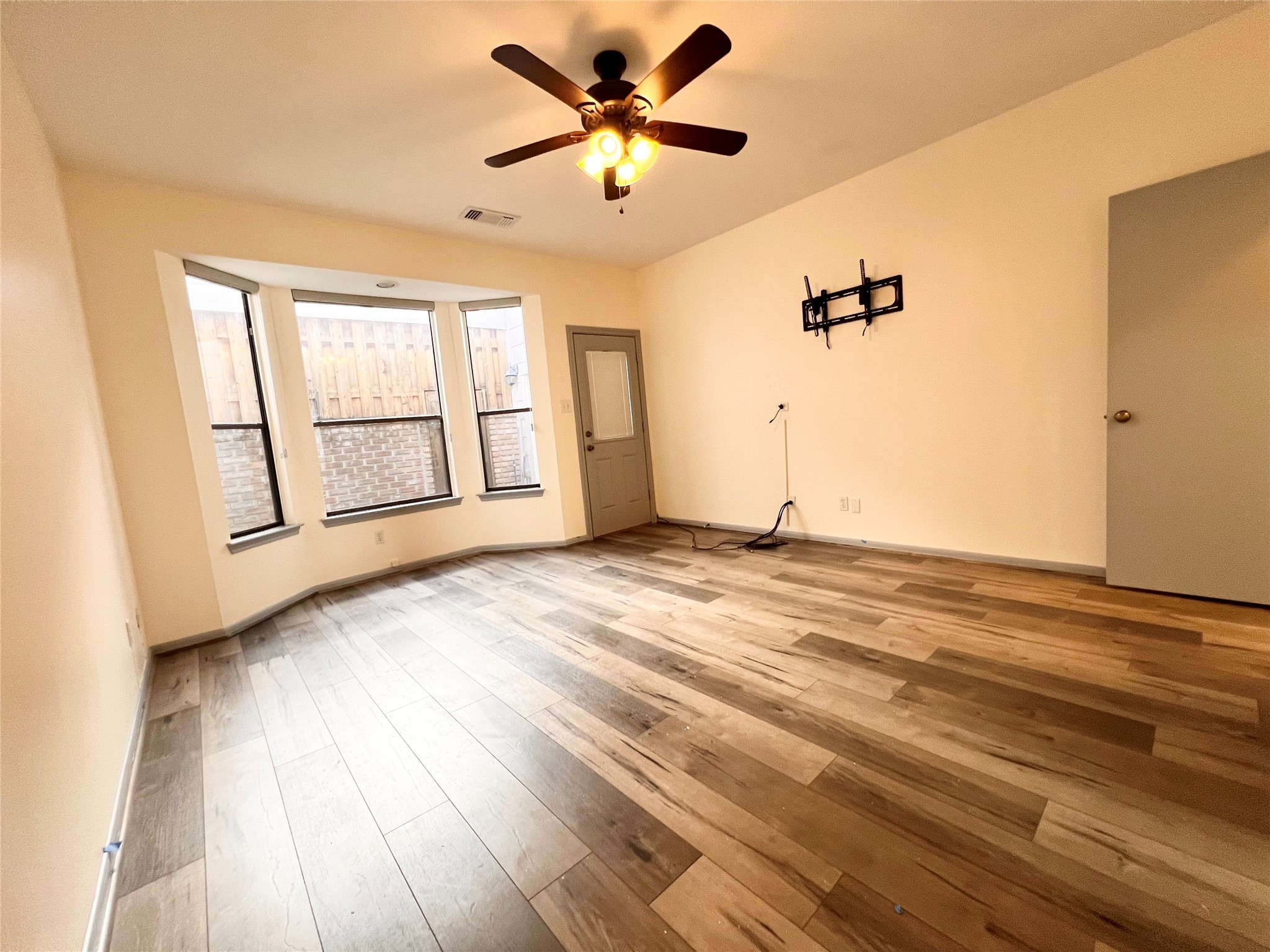 727 Bunker Hill Road, Unit 92 Houston, TX 77024 - Photo 13 of 36 a view of a livingroom with wooden floor and a ceiling fan