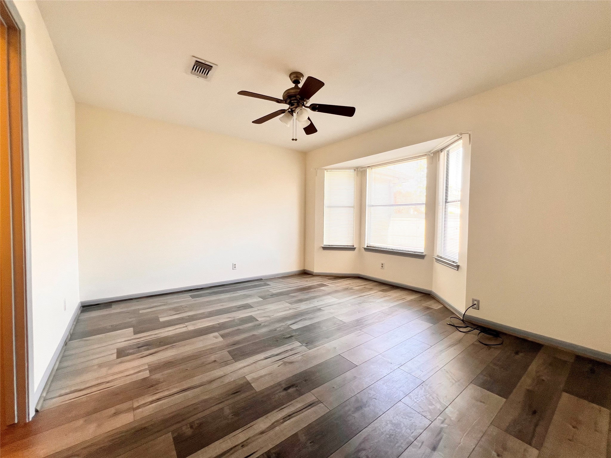 727 Bunker Hill Road, Unit 92 Houston, TX 77024 - Photo 30 of 36 an empty room with wooden floor ceiling fan and windows