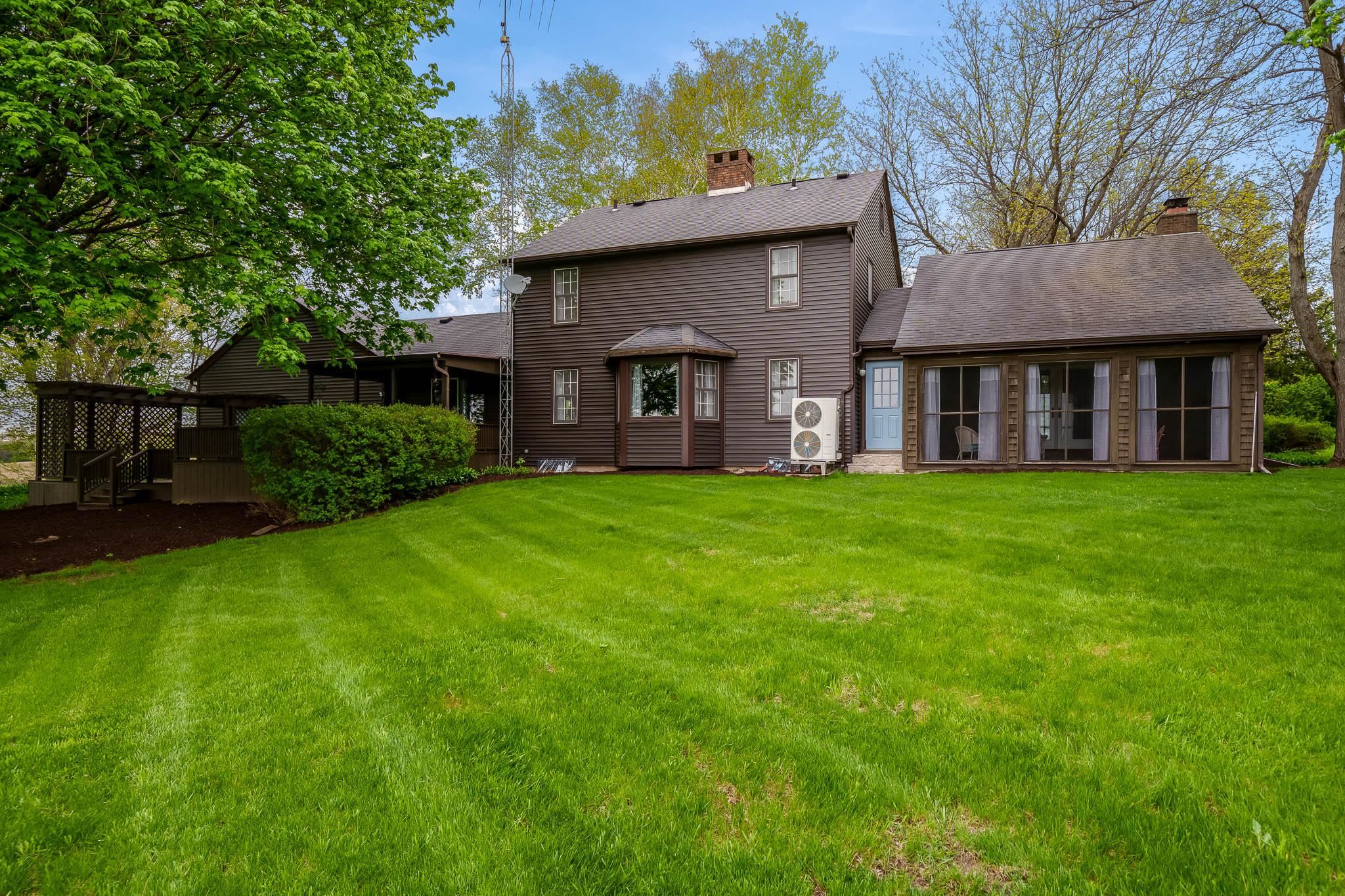 10562 Town Hall Road Belvidere, IL 61008 - Photo 3 of 72 a view of a brick house with a big yard and large trees