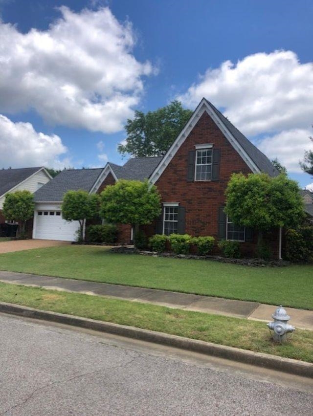 1386 Milestone Circle Collierville, TN 38017 - Photo 2 of 16 View of front of house with a front yard, driveway, brick siding, and an attached garage