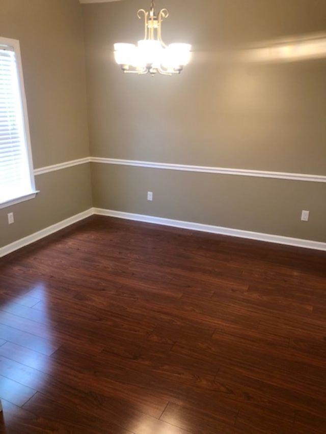 1386 Milestone Circle Collierville, TN 38017 - Photo 3 of 16 Empty room with a chandelier and dark wood-style flooring