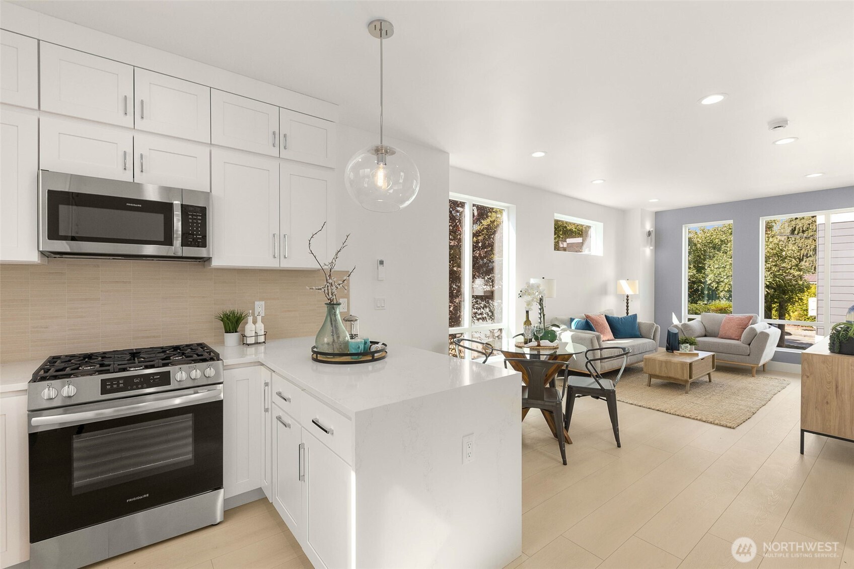 911 North 98th Street, Unit A Seattle, WA 98103 - Photo 13 of 26 a kitchen with stainless steel appliances a stove a sink a microwave a stove and white cabinets