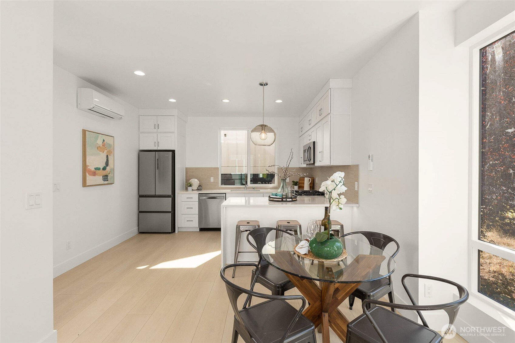 911 North 98th Street, Unit A Seattle, WA 98103 - Photo 14 of 26 a kitchen with a dining table chairs refrigerator and cabinets