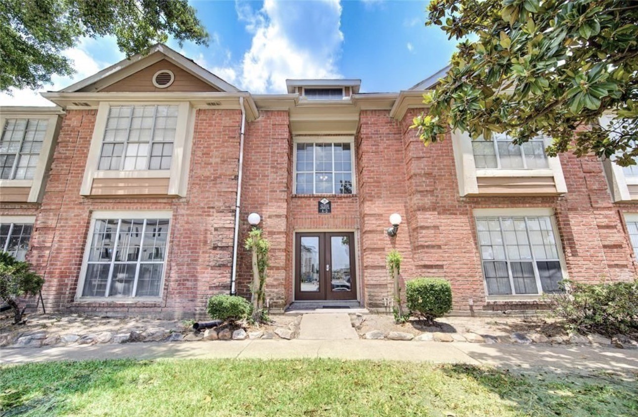 12200 Overbrook Lane, Unit 38D Houston, TX 77077 - Photo 2 of 10 front view of a brick house with a yard