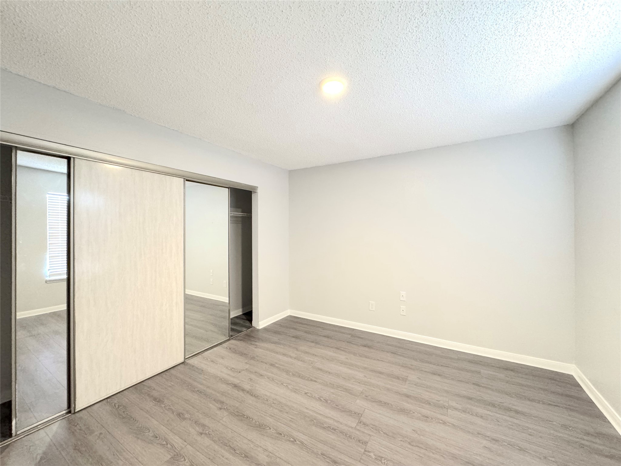 12200 Overbrook Lane, Unit 38D Houston, TX 77077 - Photo 9 of 10 an empty room with wooden floor and windows