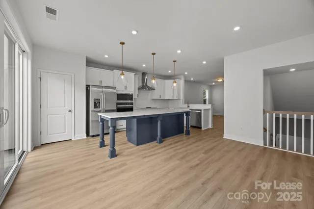 a large kitchen with stainless steel appliances kitchen island granite countertop a large cabinets a sink and a stove