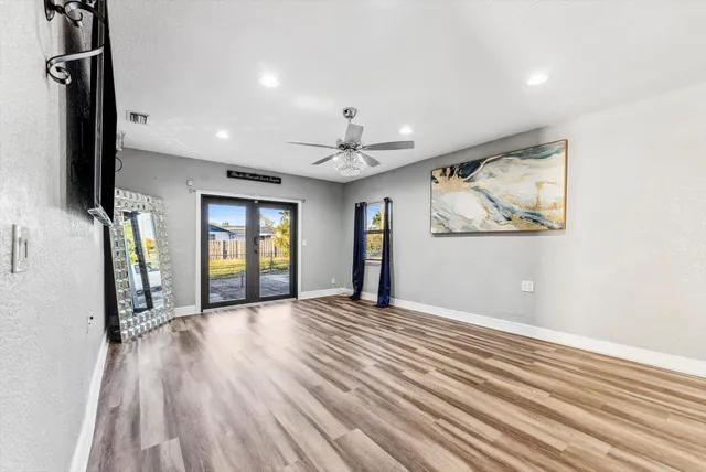 a view of a livingroom with wooden floor and a ceiling fan