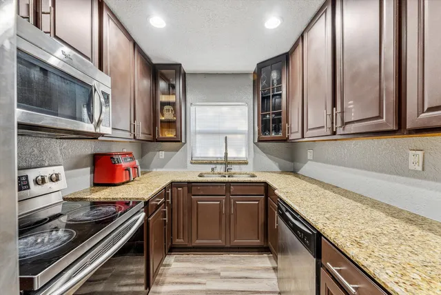 a kitchen with stainless steel appliances granite countertop a sink stove and cabinets