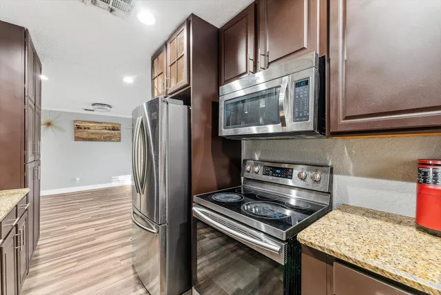 a kitchen with stainless steel appliances granite countertop a refrigerator and a stove