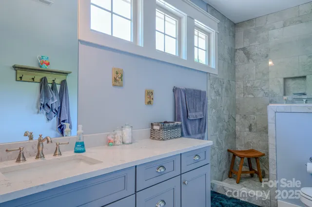 a bathroom with a granite countertop sink a toilet and shower