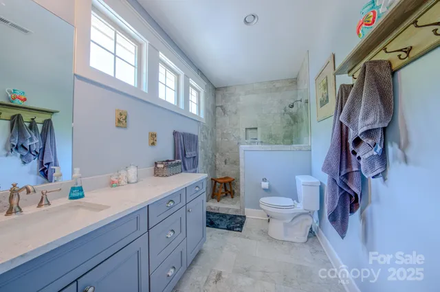 a bathroom with a double vanity sink toilet and a mirror
