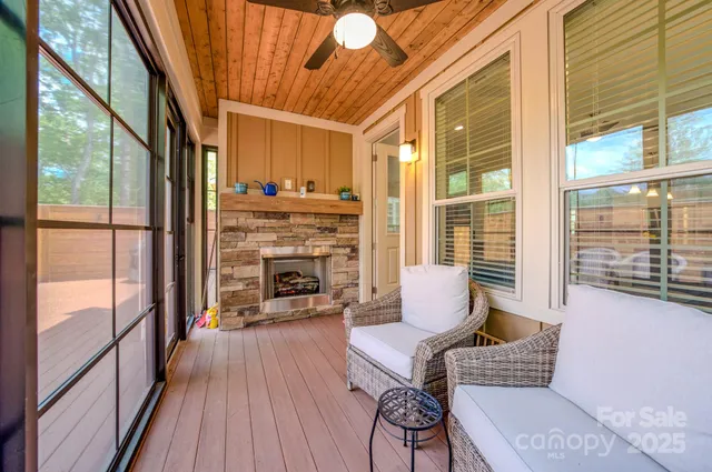 a living room with furniture a fireplace and floor to ceiling windows