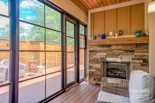 a living room with fireplace furniture and a floor to ceiling window