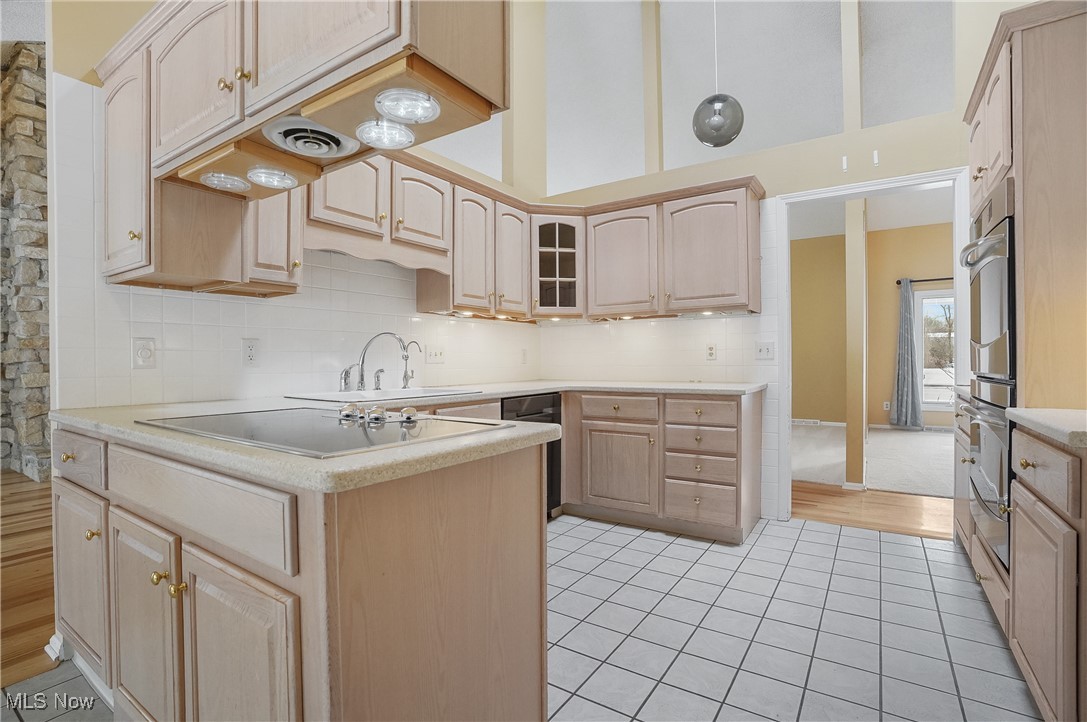 1094 San Raphael Drive Akron, OH 44333 - Photo 21 of 50 Kitchen featuring light brown cabinets, a peninsula, tasteful backsplash, light tile patterned floors, and appliances with stainless steel finishes