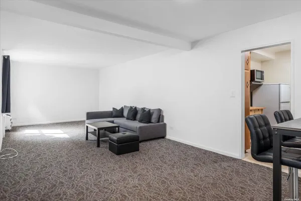 a living room with furniture and a air conditioner vent