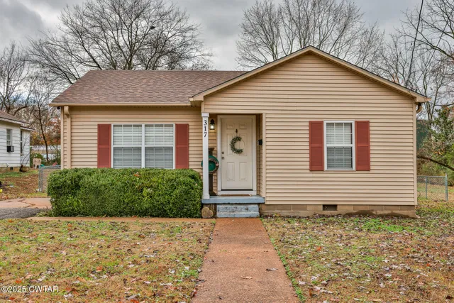 a front view of a house with a yard and potted plants