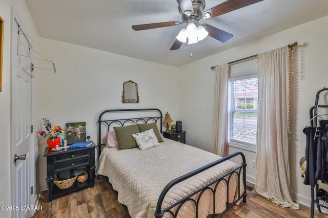 a bedroom with furniture and a fan