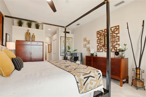 a bedroom with a large bed and a chandelier