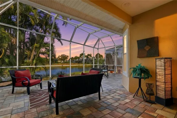 a living room with patio furniture and a potted plant