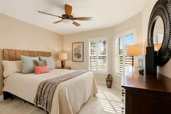a spacious bedroom with a bed a dresser and a flat screen tv