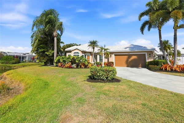a front view of a house with a yard and palm trees